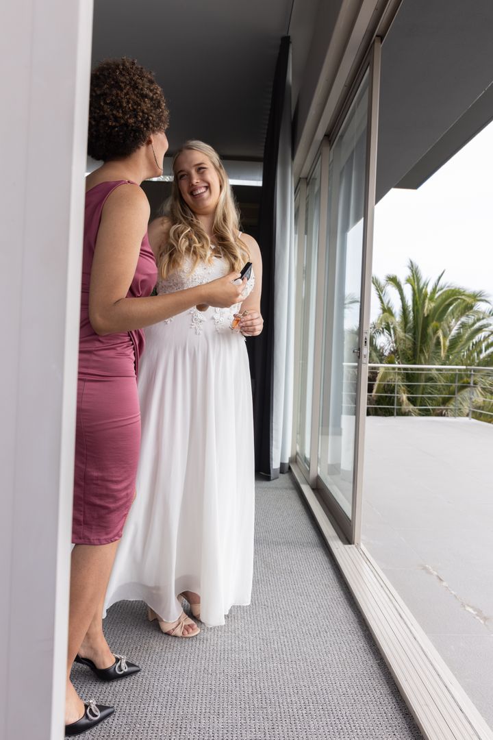 Bride with Bridesmaid Chatting by Sliding Door in Elegant Setting