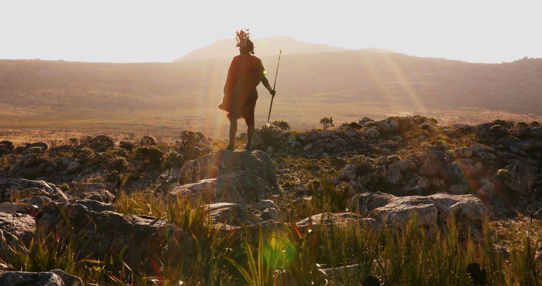 Warrior in Traditional Outfit Standing on Rocky Hills at Sunrise - Free Images, Stock Photos and Pictures on Pikwizard.com