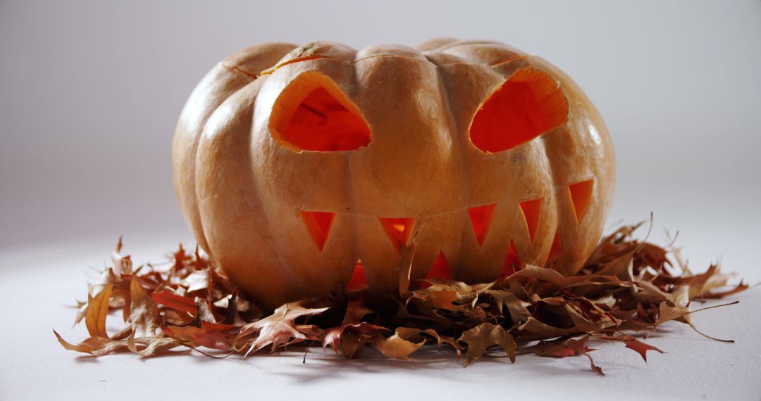 A carved pumpkin with glowing eyes adds an eerie touch to Halloween celebrations. - Free Images, Stock Photos and Pictures on Pikwizard.com