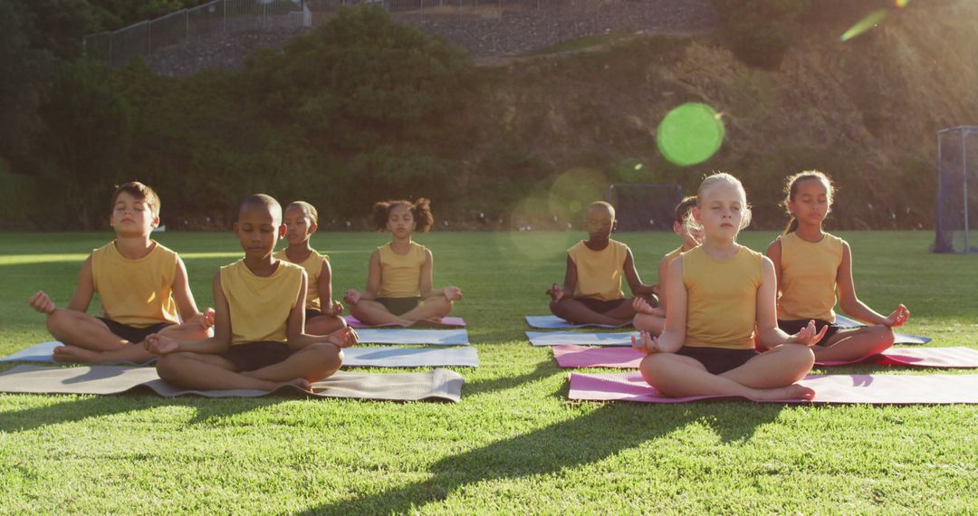 Diverse group of schoolchildren sitting on mats meditating during yoga lesson outdoors - Free Images, Stock Photos and Pictures on Pikwizard.com