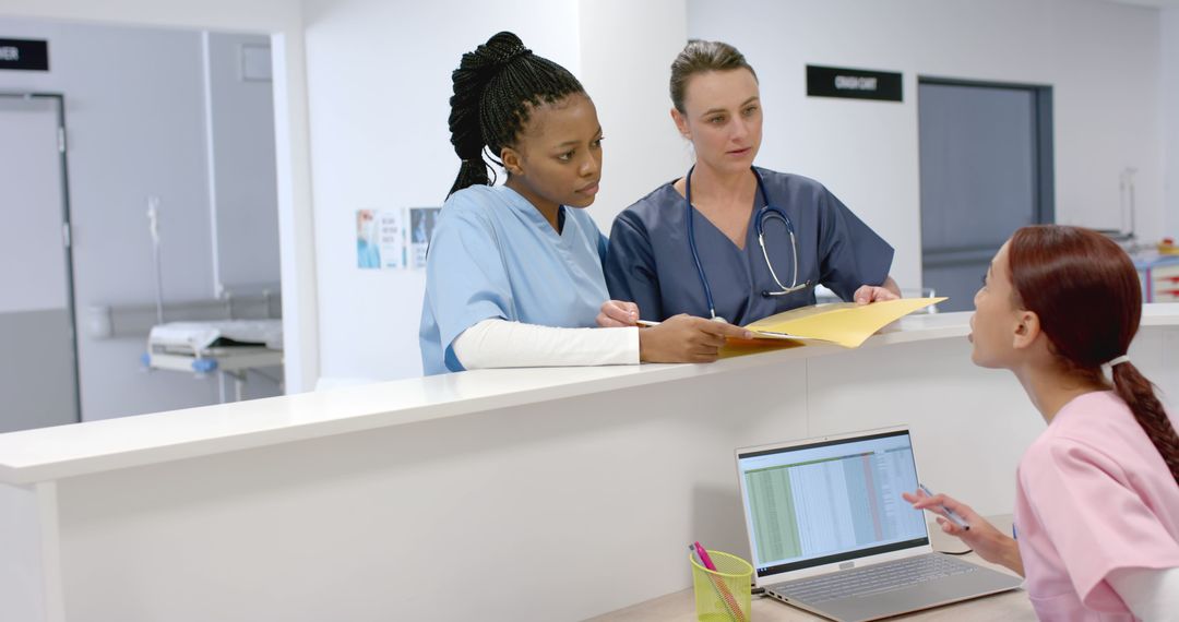 Medical Team Discussing Patient File at Hospital Reception - Free Images, Stock Photos and Pictures on Pikwizard.com