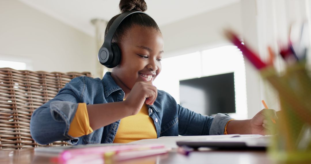 Smiling African American Girl Studying Online with Headphones at Home - Free Images, Stock Photos and Pictures on Pikwizard.com