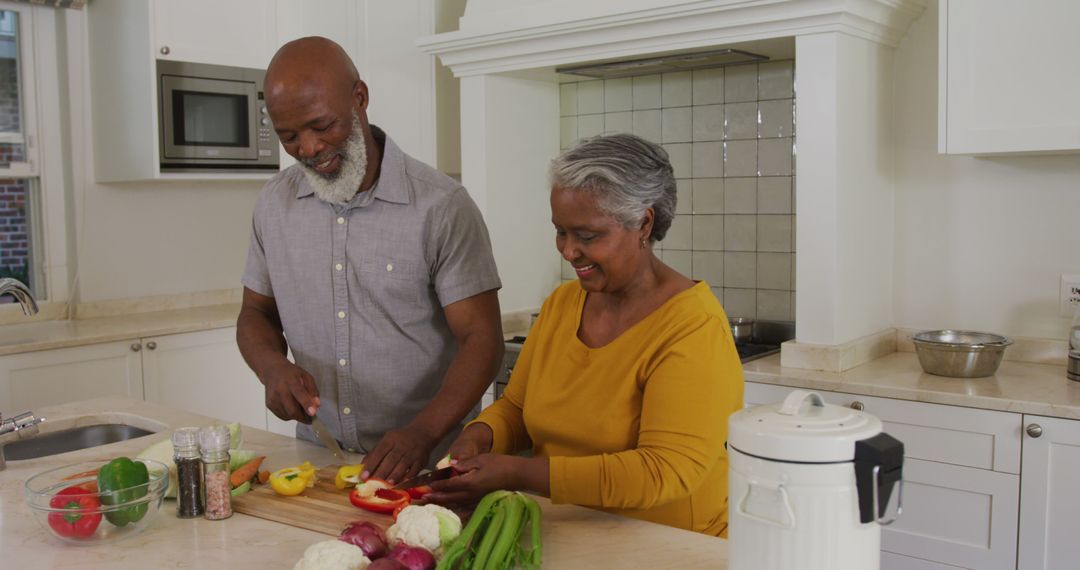 African american senior couple chopping vegetables together in the kitchen at home - Free Images, Stock Photos and Pictures on Pikwizard.com