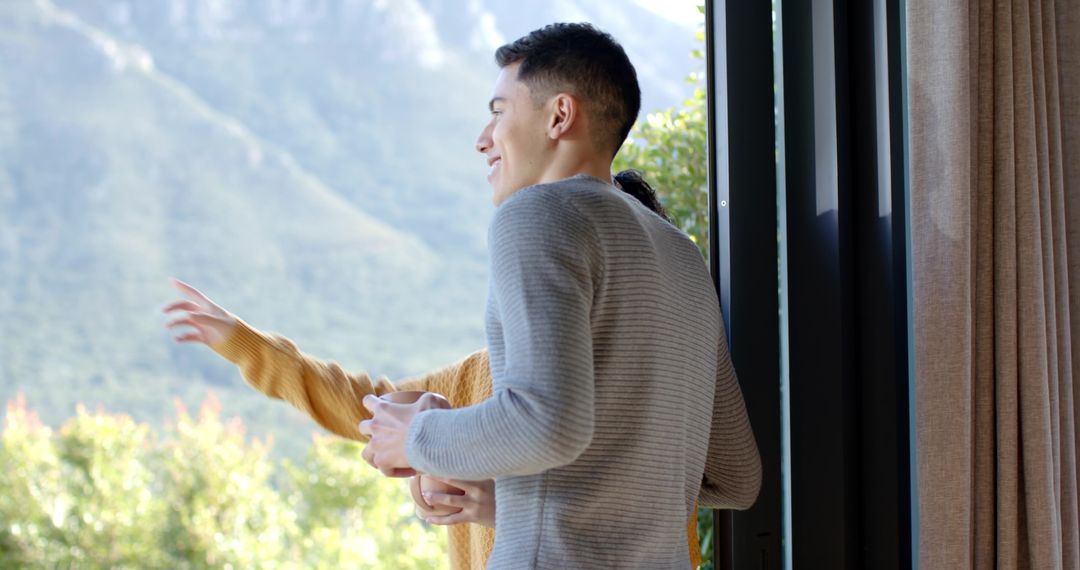 Couple Enjoying Scenic Mountain View From Balcony