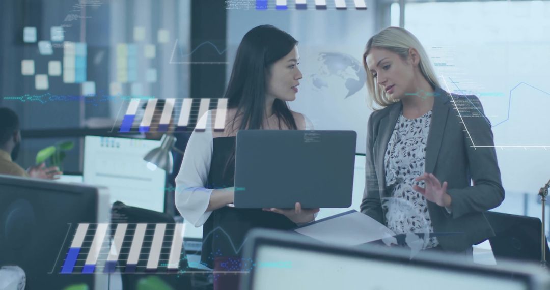 Asian professional and colleague collaborating over laptop with data overlays in office