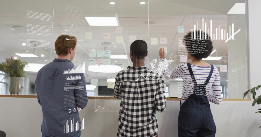 Team collaborating around glass wall with sticky notes and overlaid data visualizations