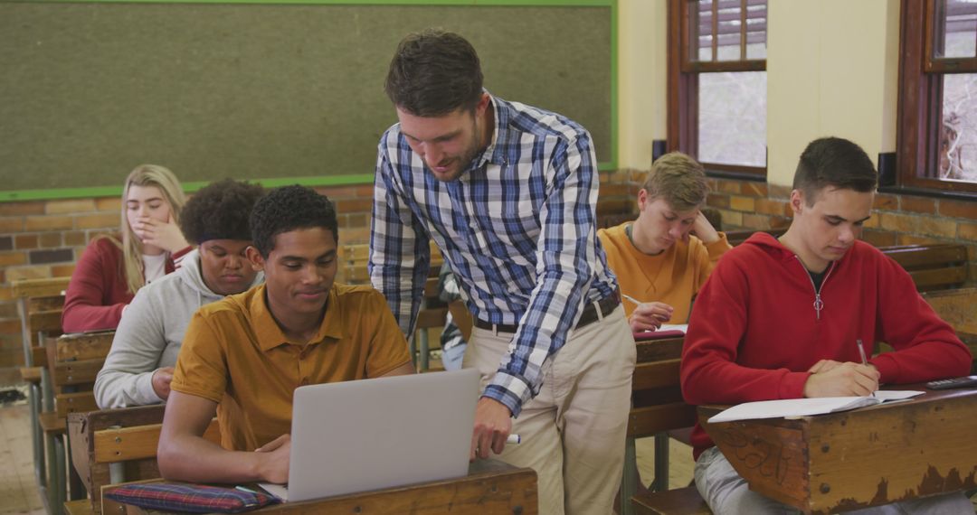 Teacher Assisting Students in Classroom with Technology