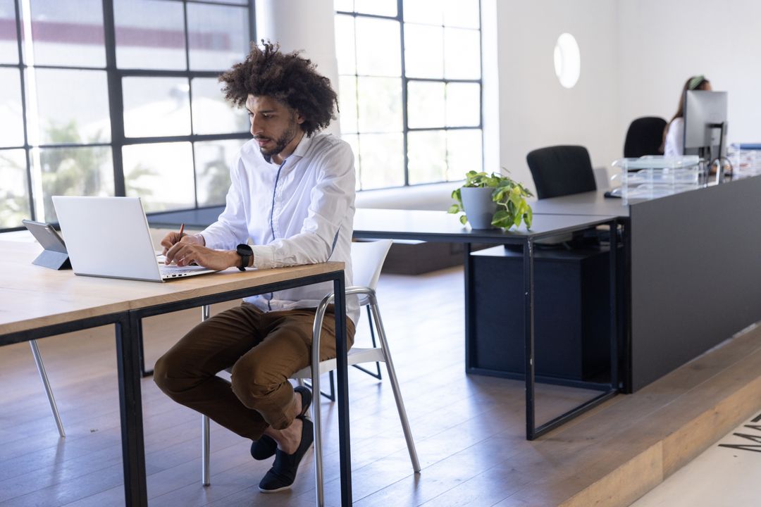 Focused Man Working at Modern Open Office with Laptop