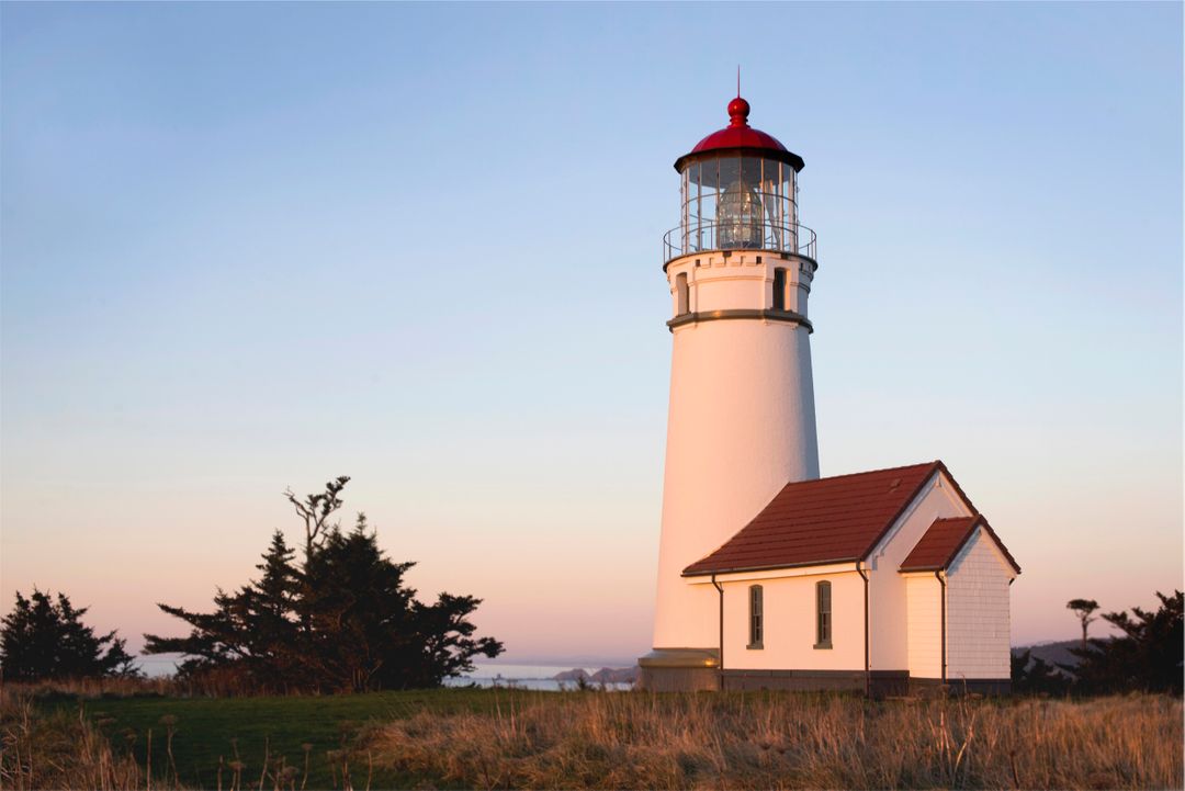 Historic White Lighthouse amid Coastal Landscape at Sunset - Free Images, Stock Photos and Pictures on Pikwizard.com