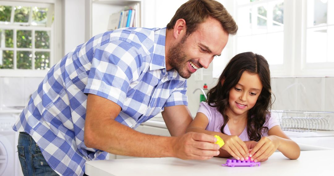 Father and Daughter Building Block Toy Together in Kitchen - Free Images, Stock Photos and Pictures on Pikwizard.com