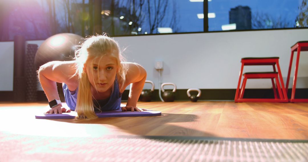 Focused Young Woman Exercising with Push-Ups on Mat in Modern Gym - Free Images, Stock Photos and Pictures on Pikwizard.com