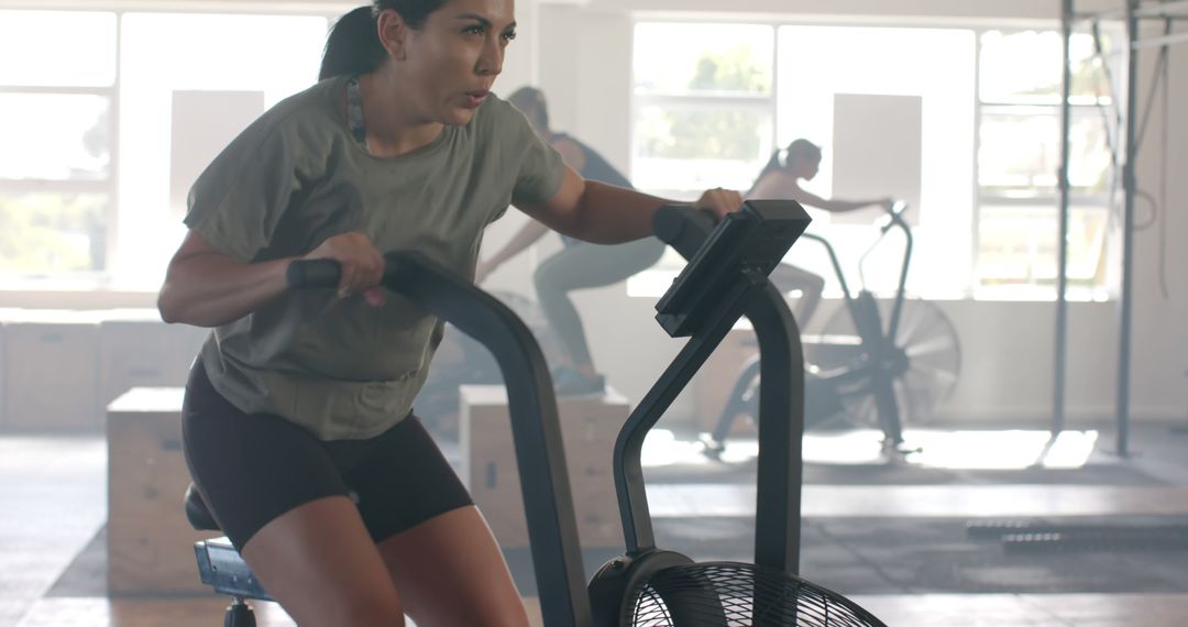 Determined Woman Exercising on Stationary Bike in Gym - Free Images, Stock Photos and Pictures on Pikwizard.com