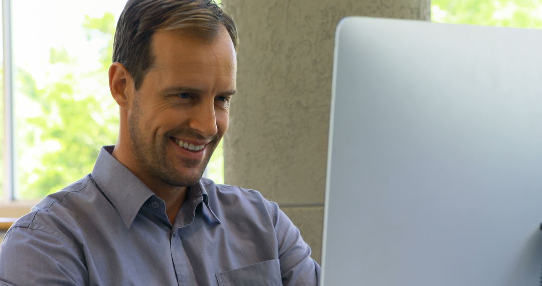 Smiling Caucasian Man Enjoying Computer Work in Bright Office - Free Images, Stock Photos and Pictures on Pikwizard.com