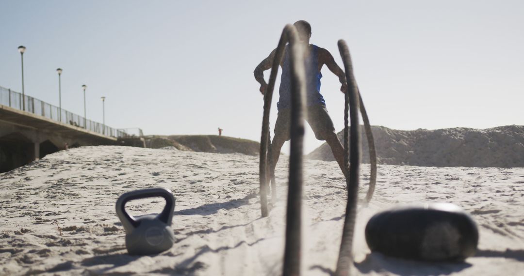 Man Engaging in Intense Beach Workout with Battle Ropes - Free Images, Stock Photos and Pictures on Pikwizard.com