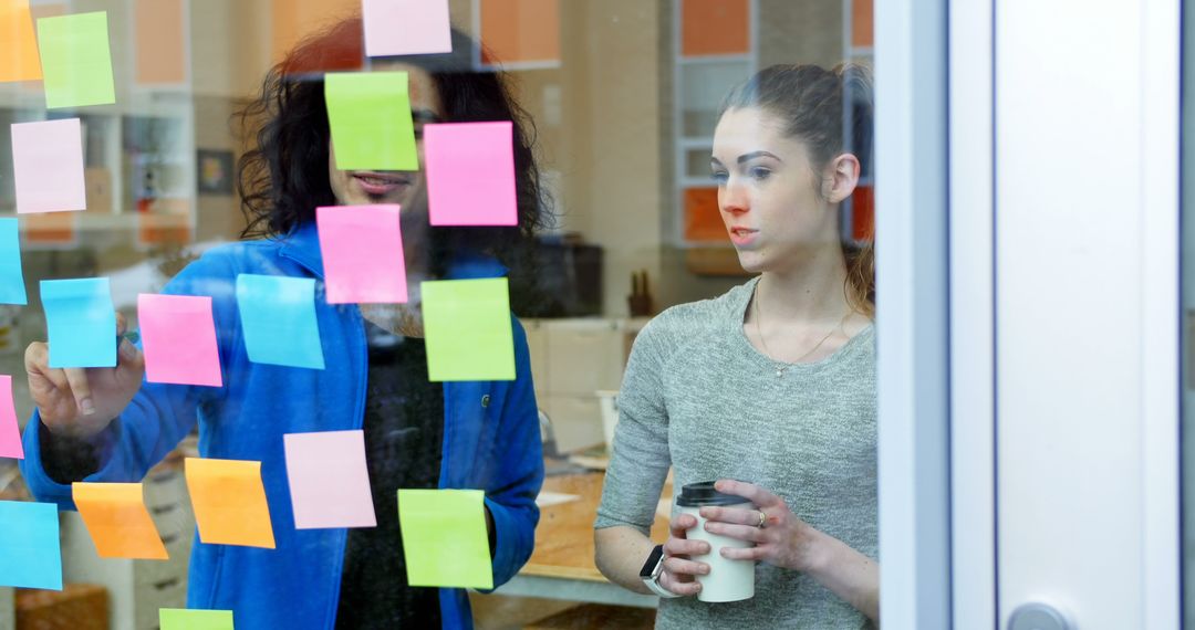 Team Collaborating on Project with Sticky Notes on Glass Wall - Free Images, Stock Photos and Pictures on Pikwizard.com