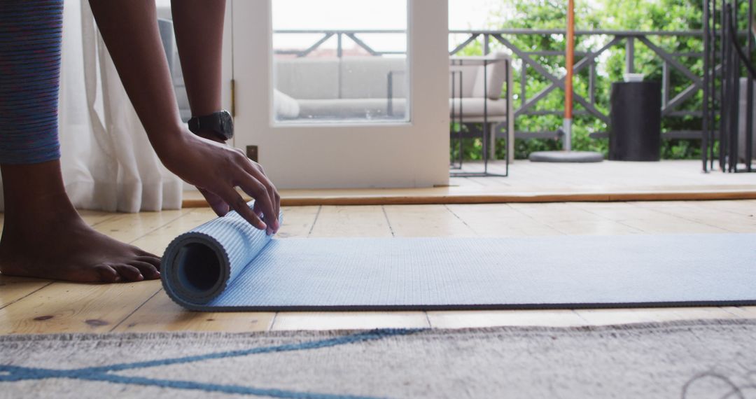 Unrolling Yoga Mat at Home on Wooden Floor - Free Images, Stock Photos and Pictures on Pikwizard.com