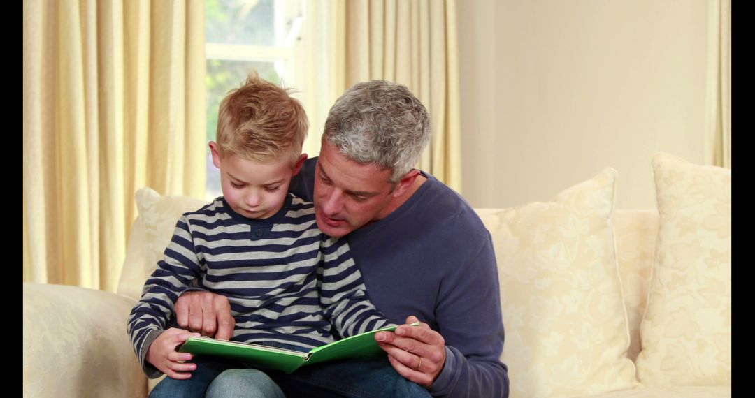 Father reading storybook with young son on cozy couch - Free Images, Stock Photos and Pictures on Pikwizard.com