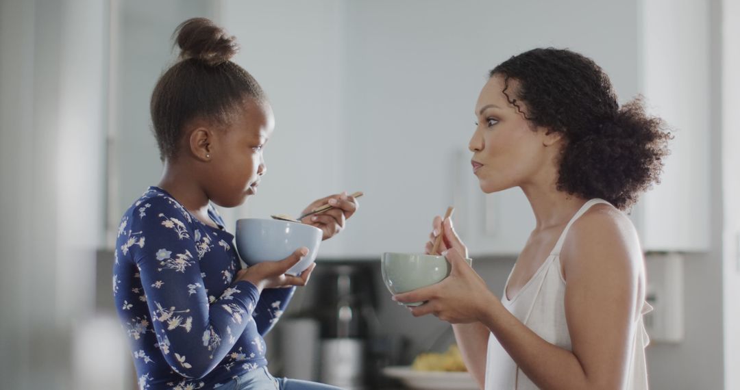 African American Mother and Daughter Eating Breakfast Together - Free Images, Stock Photos and Pictures on Pikwizard.com