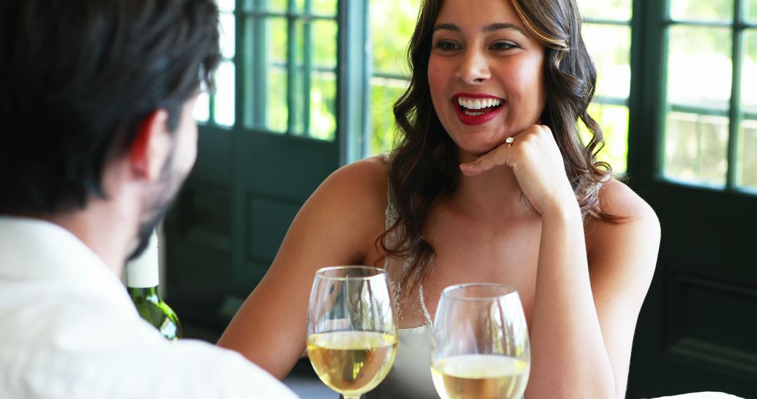 A young, Caucasian woman enjoys a conversation with a man over glasses of wine, with copy space - Free Images, Stock Photos and Pictures on Pikwizard.com