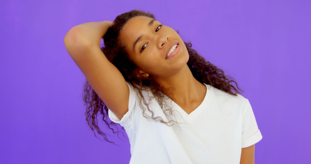 Cheerful Young Woman Posing Against Vivid Purple Background - Free Images, Stock Photos and Pictures on Pikwizard.com