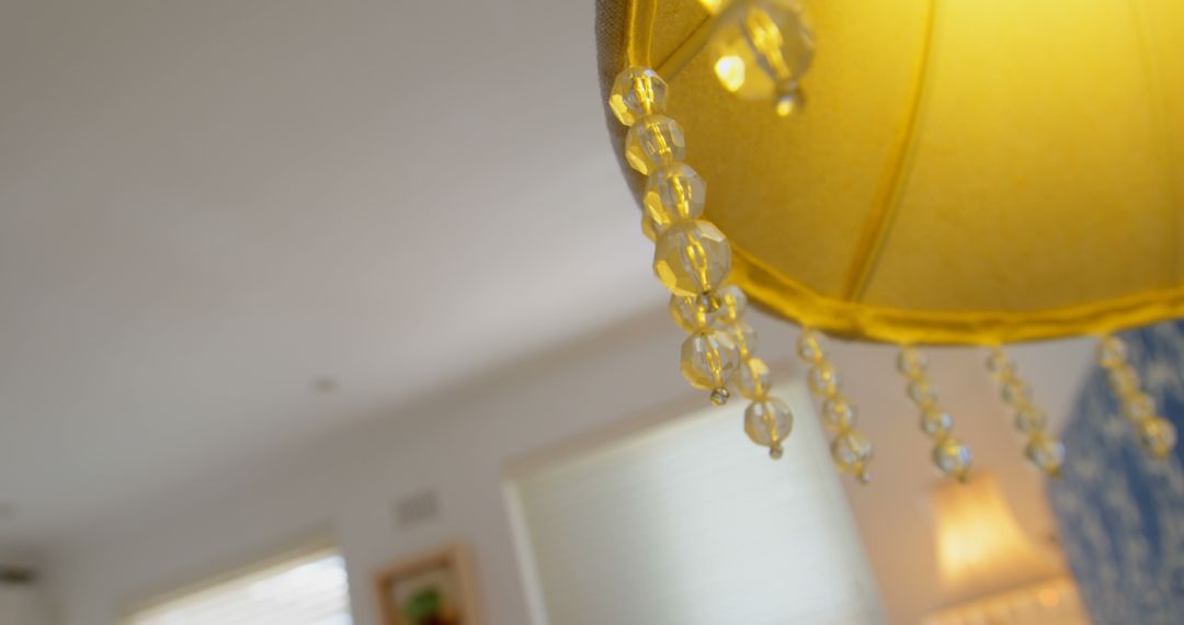 Close-up of Elegant Yellow Lamp with Beaded Details in Cozy Home