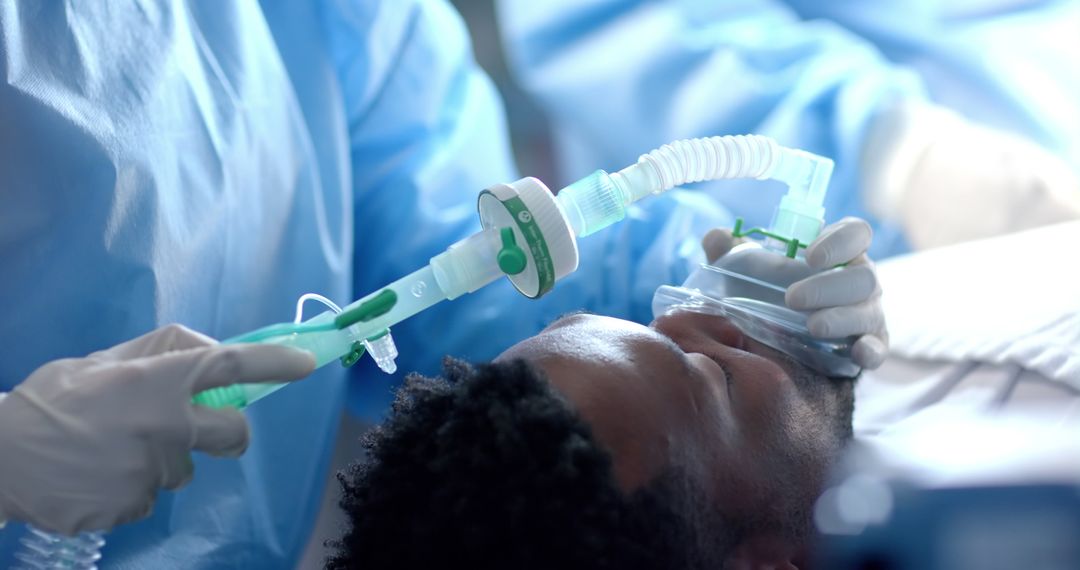 Surgeons with medical gloves during surgery on african american male patient with oxygen mask - Free Images, Stock Photos and Pictures on Pikwizard.com