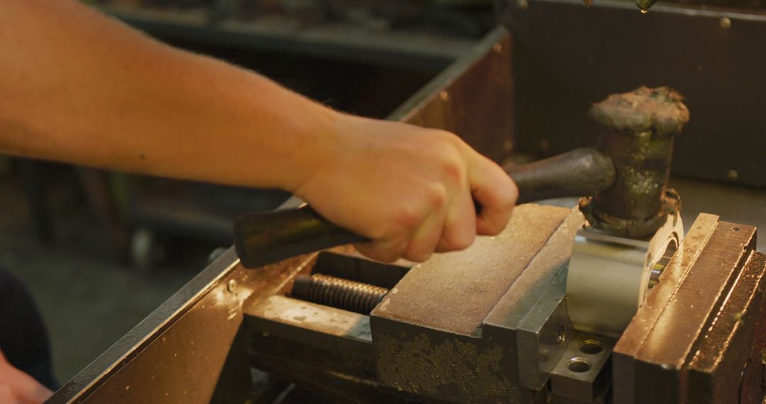 Worker using mallet on workbench in metal workshop - Free Images, Stock Photos and Pictures on Pikwizard.com