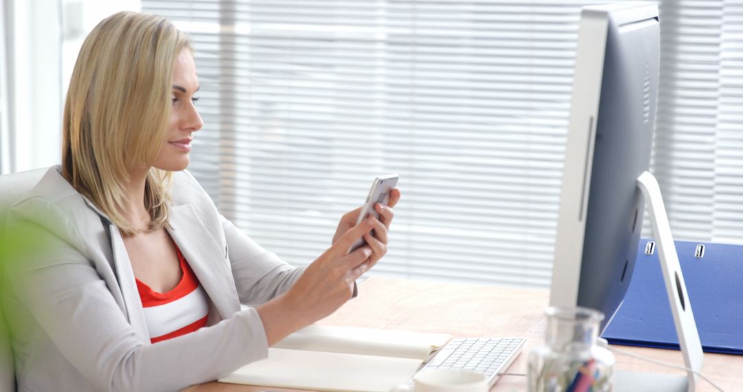 Professional Woman Using Smartphone at Modern Office Desk - Free Images, Stock Photos and Pictures on Pikwizard.com