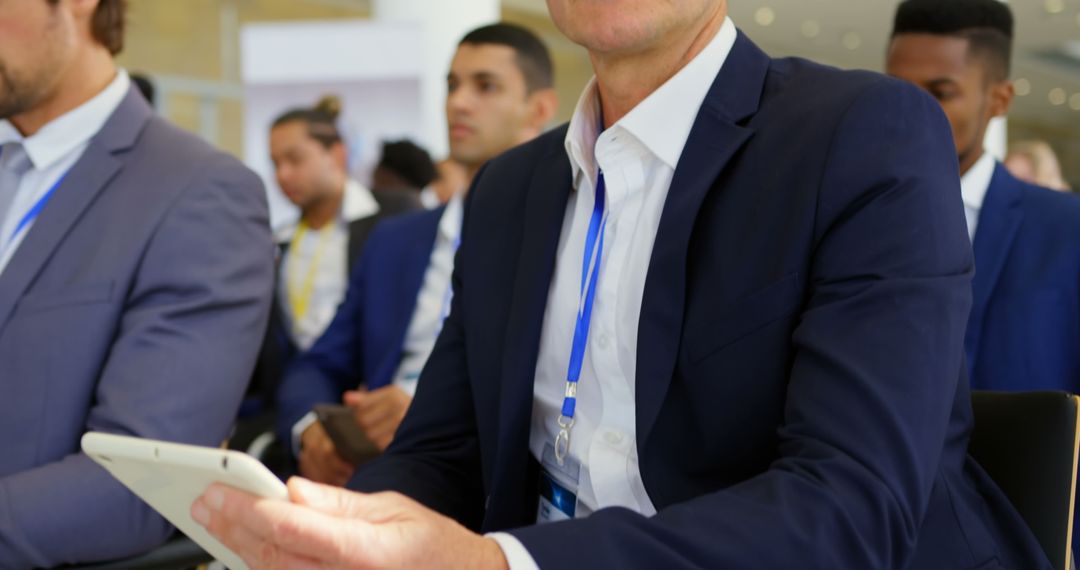 Businessman in Formal Attire Attending Seminar with Tablet