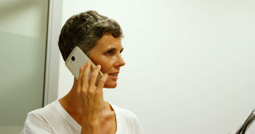 Professional Woman with Short Hair Talking on Smartphone in Office - Free Images, Stock Photos and Pictures on Pikwizard.com