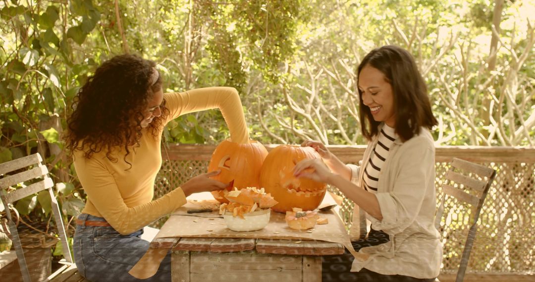 Friends Carving Pumpkins on Rustic Porch Making Jack-o'-Lanterns for Autumn Gathering