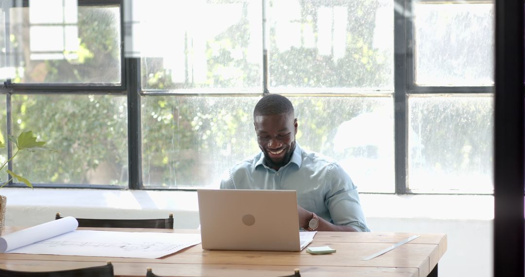 Smiling Professional Businessman Working on Laptop in Bright Office