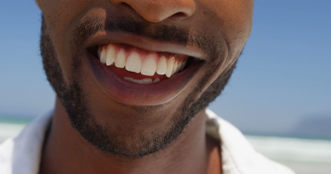 Close-Up of Smiling Man on Sunny Beach - Free Images, Stock Photos and Pictures on Pikwizard.com