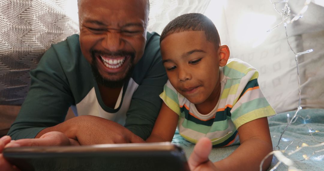 Father and Son Enjoying Quality Time with Tablet Under Fort - Free Images, Stock Photos and Pictures on Pikwizard.com