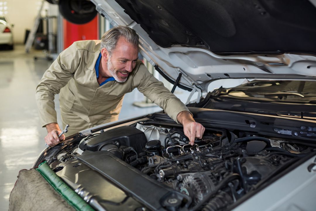 Experienced Mechanic Examining Car Engine in Auto Repair Workshop