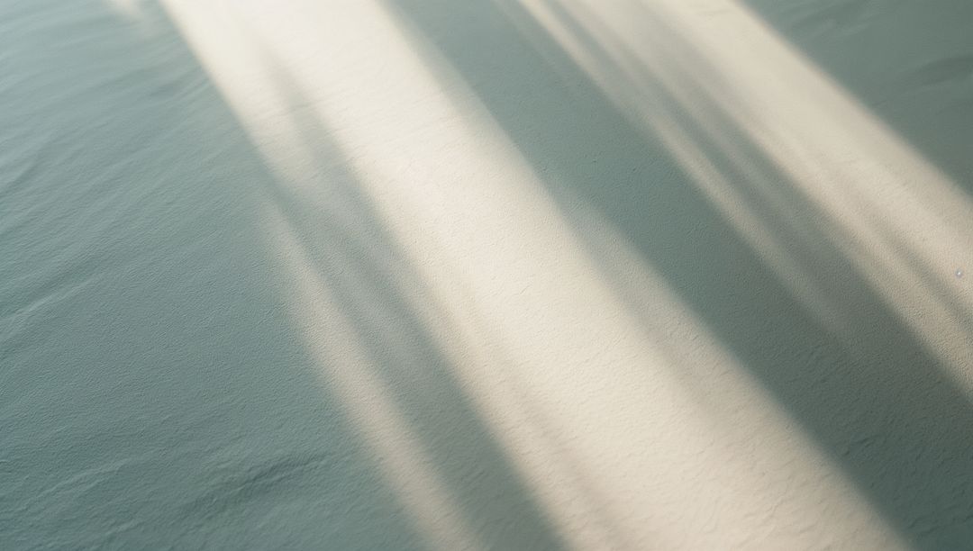 Diagonal Sunlight Patterns Casting Shadows on Minimalist Floor