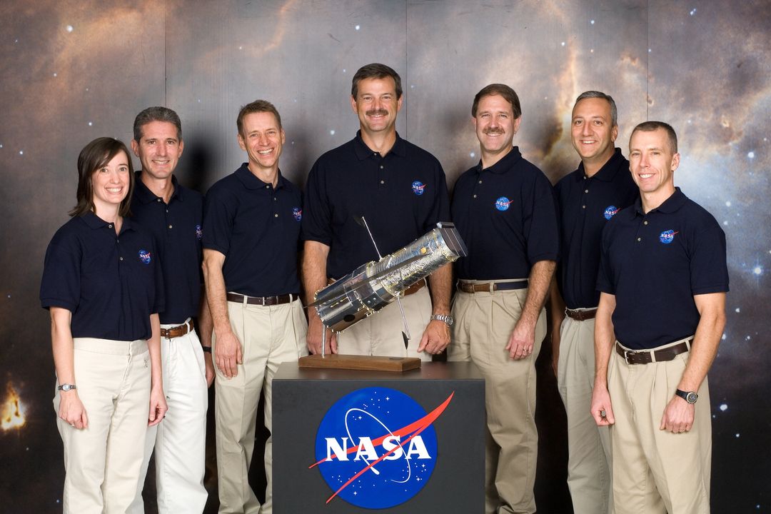 NASA STS-125 Crew Members Standing Together with Space Telescope Model