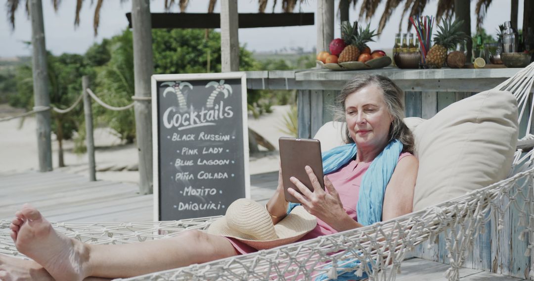 Senior Woman Relaxing with Tablet on Tropical Beach - Free Images, Stock Photos and Pictures on Pikwizard.com