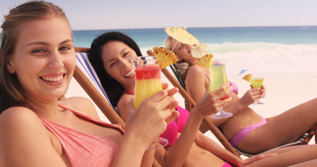 Young Women Relaxing on Beach with Tropical Drinks - Free Images, Stock Photos and Pictures on Pikwizard.com