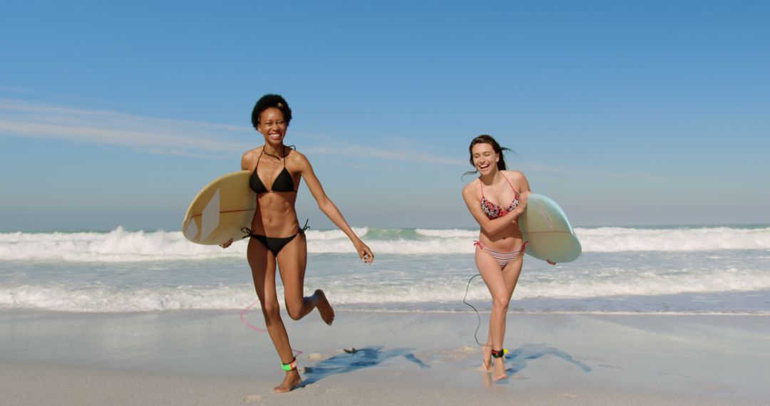 Two Young Women Running on Beach with Surfboards on Sunny Day - Free Images, Stock Photos and Pictures on Pikwizard.com