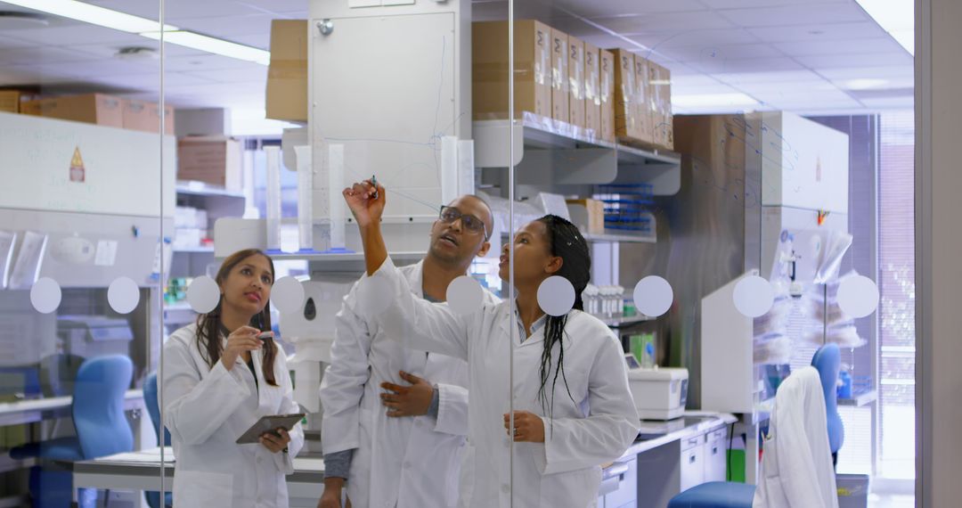 Biomedical Researchers Discussing Data on Glass Wall Inside Laboratory - Free Images, Stock Photos and Pictures on Pikwizard.com