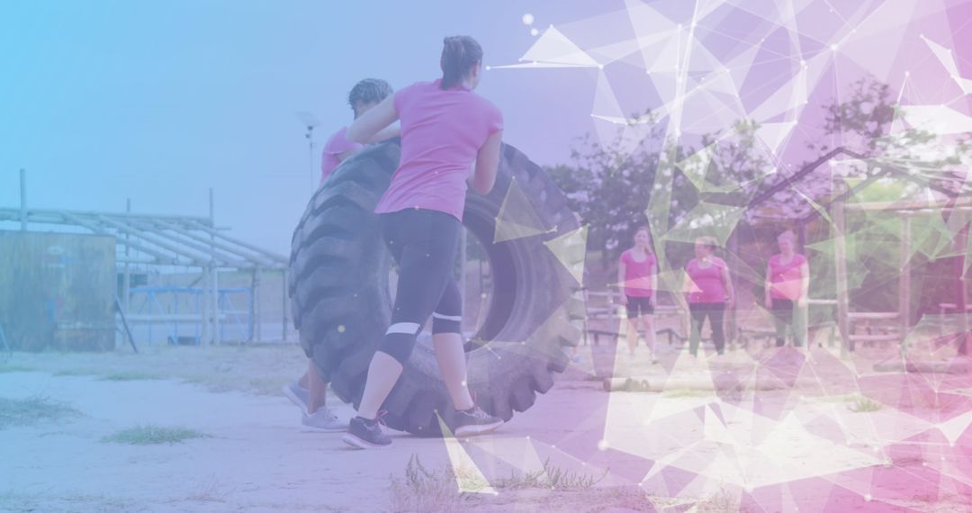 Women Participating in Tire Flip Challenge on Obstacle Course
