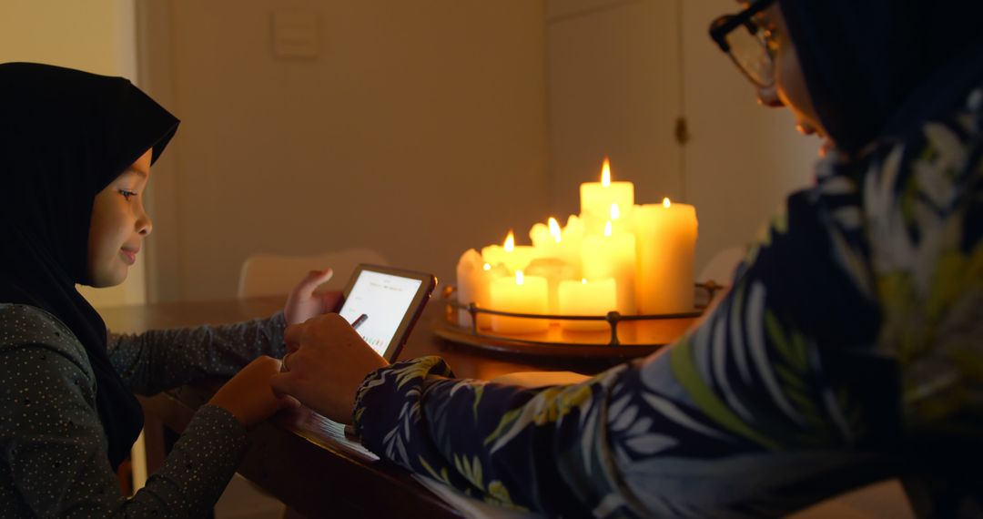 Mother and Daughter Using Tablet in Candlelit Room - Free Images, Stock Photos and Pictures on Pikwizard.com