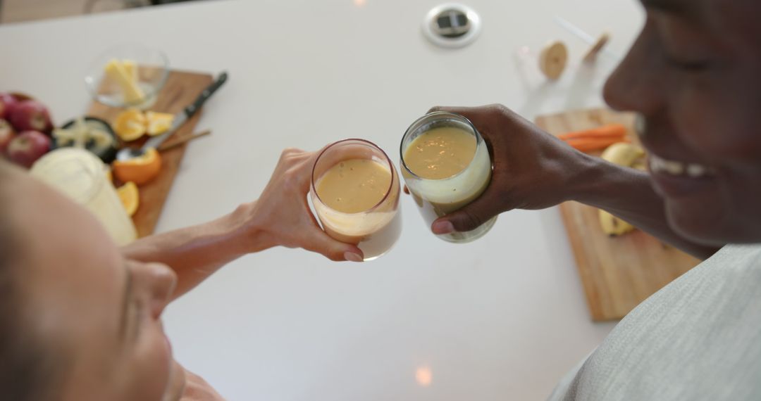 Diverse Couple Toasting with Healthy Smoothies in Modern Kitchen