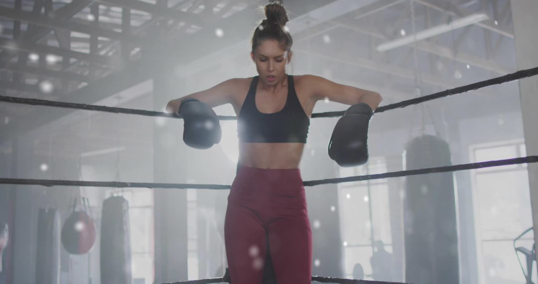 Female Boxer Resting on Rope Closing Eye During Training at Gym