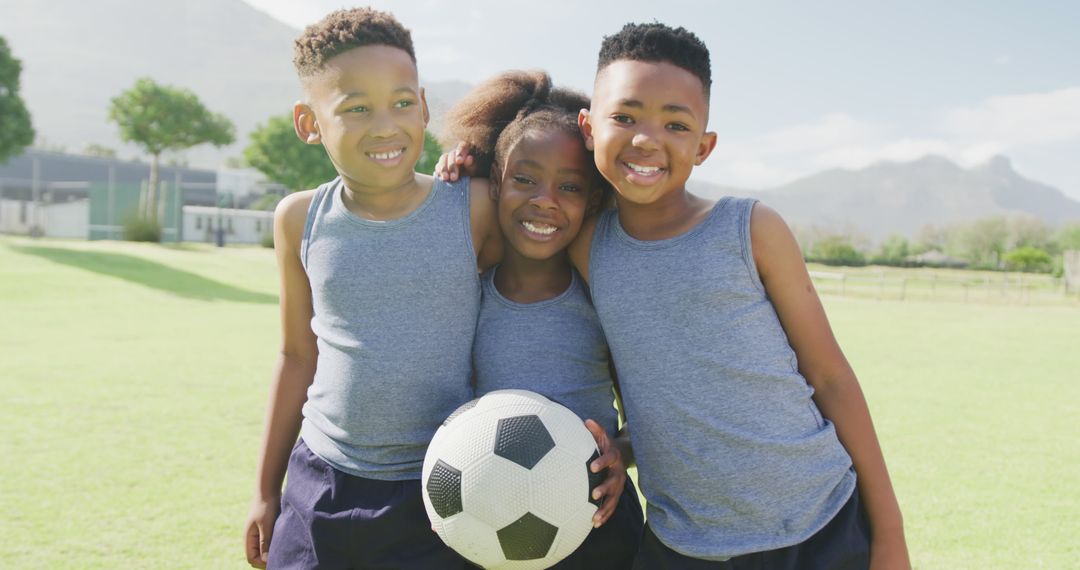 Image portrait of three happy african american children holding football in school field - Free Images, Stock Photos and Pictures on Pikwizard.com