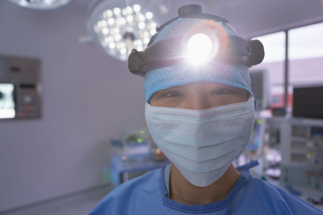 Female surgeon standing with surgical headlight in operation room at hospital - Free Images, Stock Photos and Pictures on Pikwizard.com