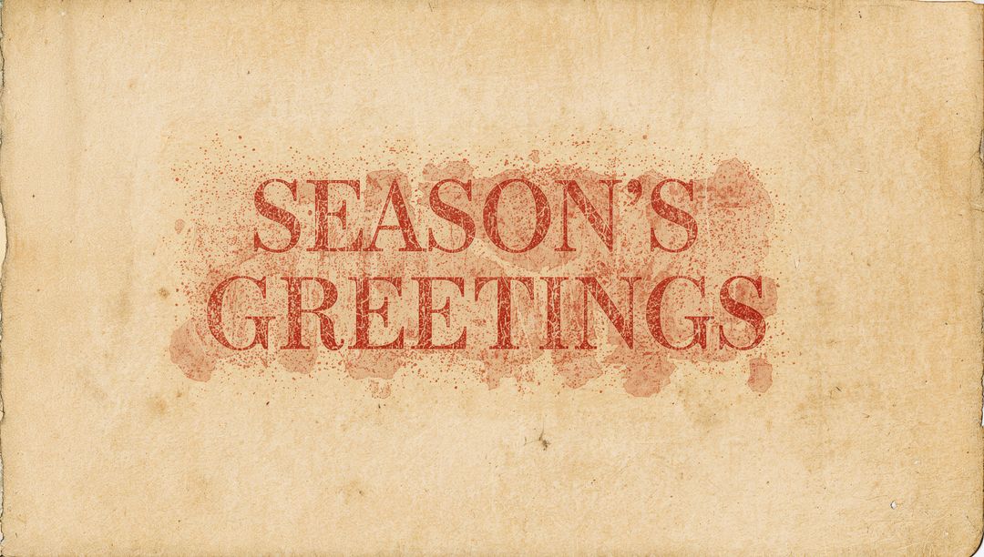 Vintage Season's Greetings Typography on Aged Parchment with Distressed Ink Splatter
