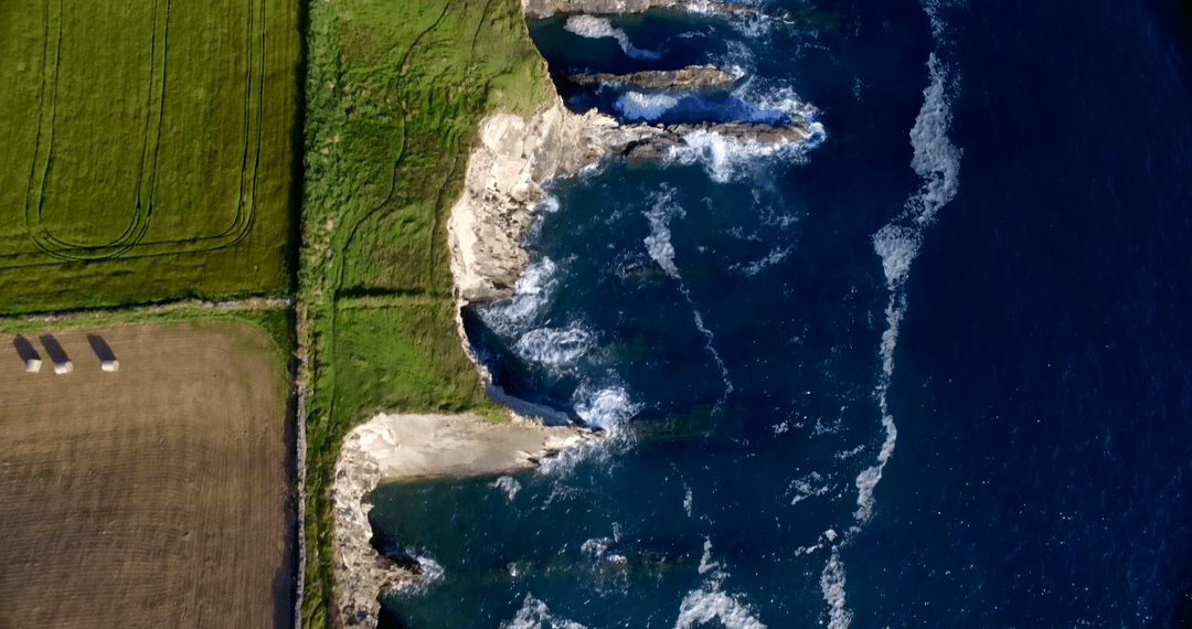 Aerial Transparent Water Flow by Rugged Cliff Edge