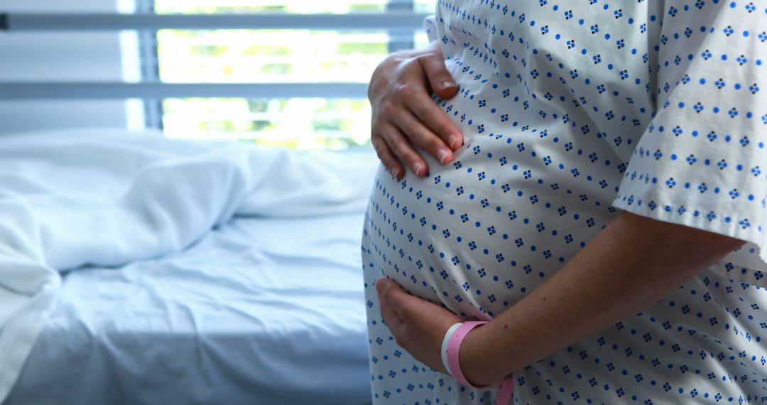 Pregnant Woman in Hospital Gown Touching Belly - Free Images, Stock Photos and Pictures on Pikwizard.com